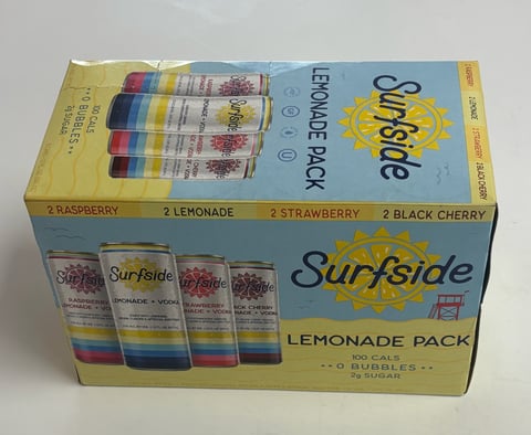 Surfside lemonade pack box with four cans in raspberry, lemonade, strawberry, and black cherry flavors