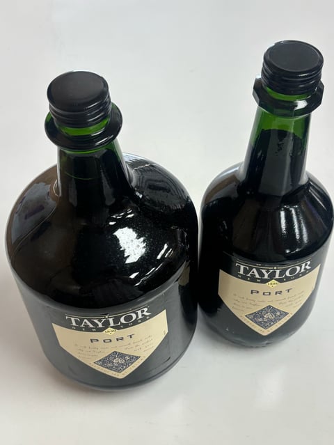 Two Taylor Port wine bottles with black caps and cream-colored labels on a white background.
