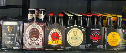 Collection of Guinness beer bottles and packaging displayed in a row on a shelf