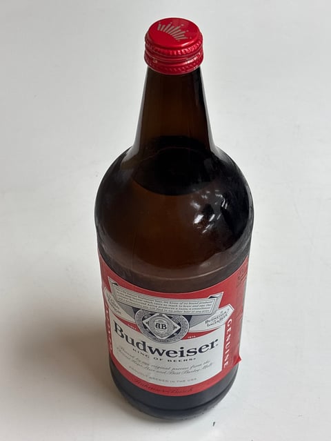 Budweiser beer bottle with red cap and label on white background