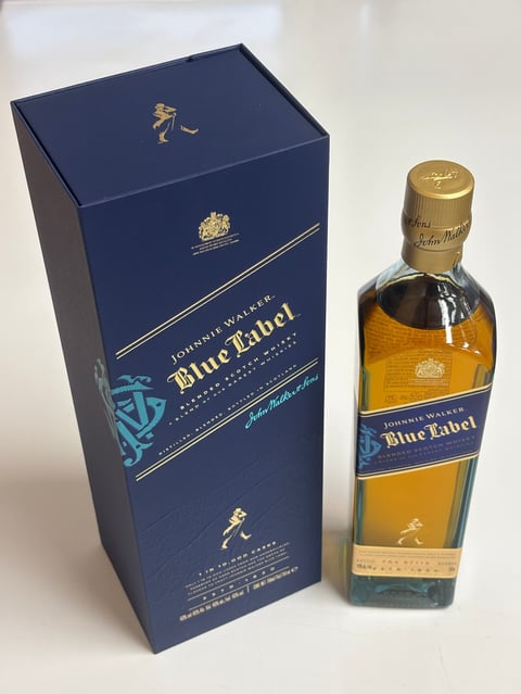 Johnnie Walker Blue Label whisky bottle with its navy blue presentation box on white background